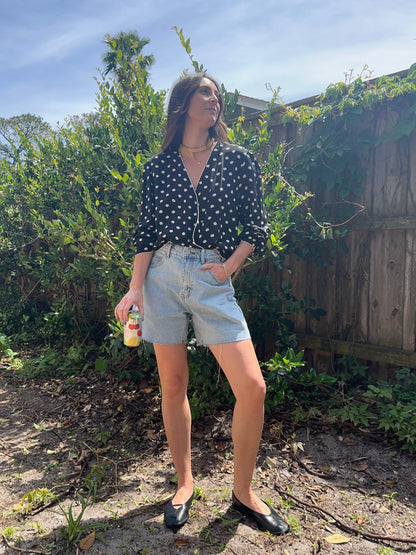 Girl standing wearing vintage polka dot blouse, retro wrap blouse. 