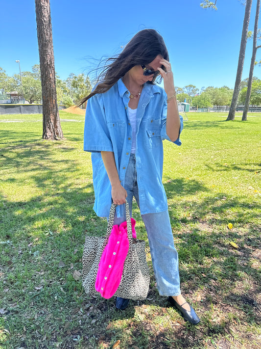 Girl in park wearing vintage denim shirt for women, holding leopard tote bag with american vintage clothing vitow cardigan in bright pink.