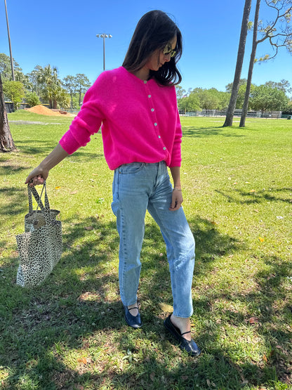 Girl wearing bright pink American Vintage Clothing Vitow Cardi holding Garance Paris Leopard Print Tote Bag and trendy charm necklace