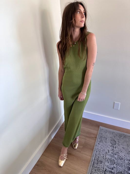 Girl wearing green knit open back maxi dress with gold flats and gold  necklace