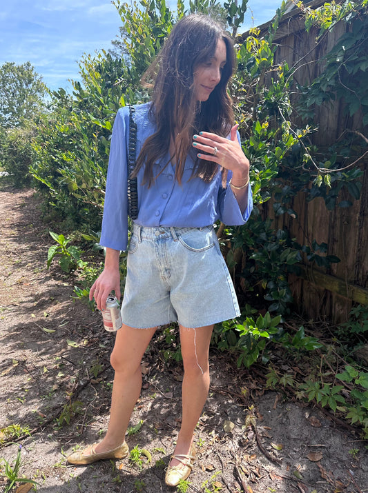 Girl standing in front of bush wearing vintage collared blouse for women.