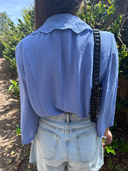 Girl standing in front of bush wearing vintage collared blouse for women.