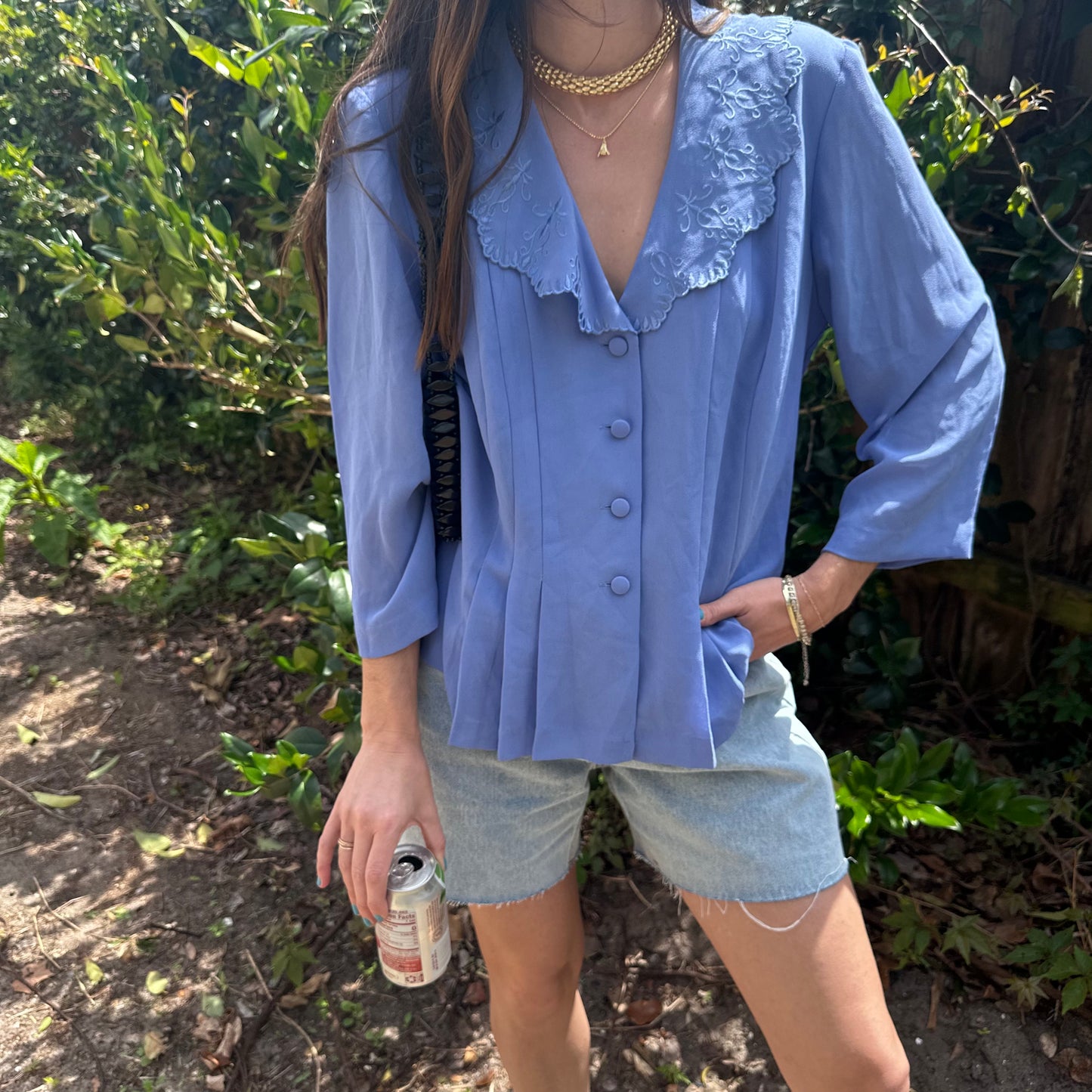 Girl standing in front of bush wearing vintage collared blouse for women.